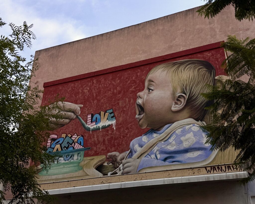 "A Spoonful of Love" outdoor mural by WANJA.