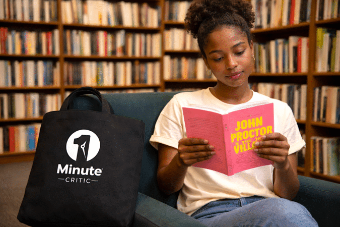 A young Black woman reads the script for "John Proctor is the Villain" in a bookstore.