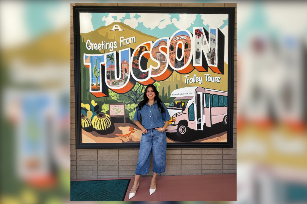 Artist Camila Ibarra in front of the mural she painted for Tucson Trolley Tours.