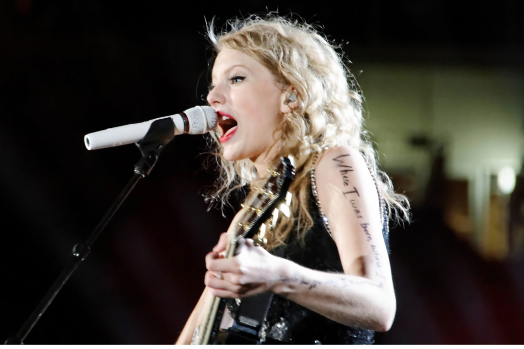 Taylor Swift playing the guitar in concert
