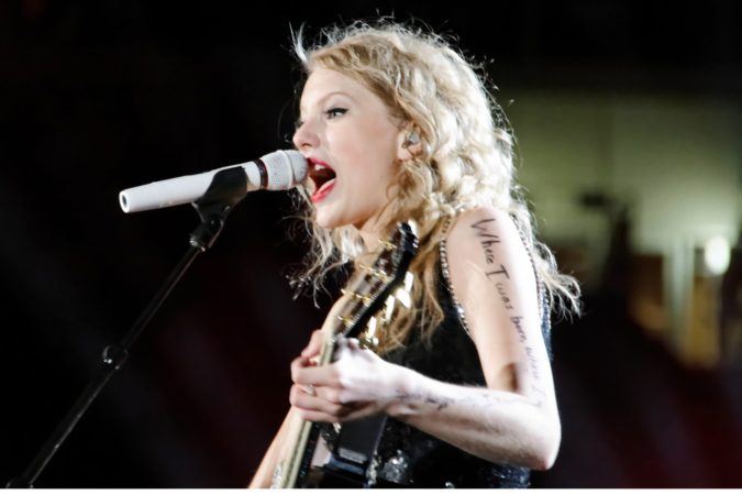 Taylor Swift playing the guitar in concert