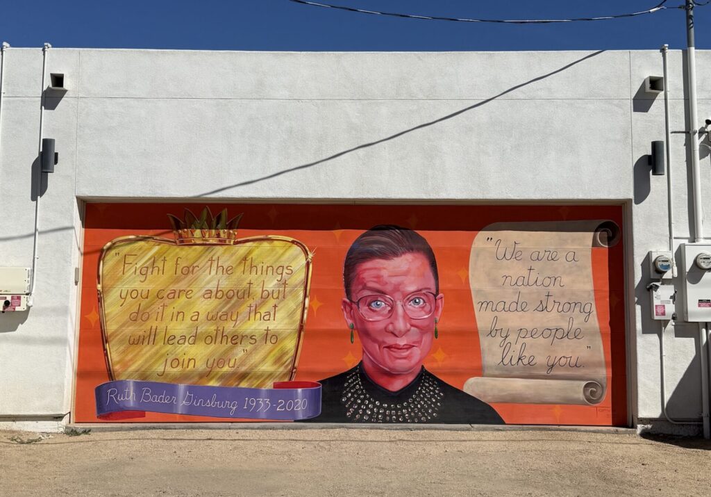 Ruth Bader Ginsburg, flanked by two of her quotes, painted on a garage door.
